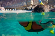 Snorkling out from shore, sea kayakers on the beach. Isla Carmen, Sea of Cortez, Baja, Mexico.