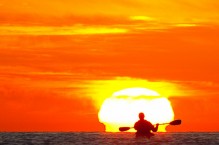 Sea kayaker paddles toward sunrise, Sea of Cortez, Baja, Mexico.