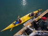 Captain Jim Kyle hands off a paddle, with assist from kayak guide Benson.