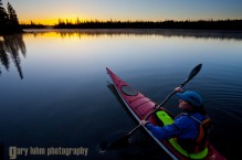 Woman sea kayaker on BIg Lake, Oregon at sunrise.