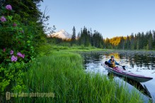 A woman in a sea kayak paddles on Trillium Lake, Oregon.