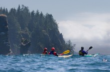 Sea kayakers approach moody storm at Cape Flattery, Washington State.
