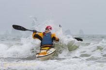 Sea kayaker Alan Marshall busts through mild surf at Third Beach, Olympic National Park, Washington State.