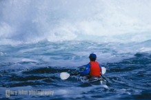 Sea kayaker Diane Civic approaches on off-shore rock in the Broken Group, Vancouver Island, Canada.