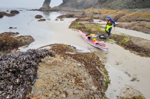 Sea kayaker packs kayak at Point-of-Arches, Olympic National Park