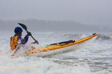 Sea kayaker launching from Makah Bay, Olympic Coast, Washington State.