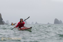 Woman sea kayaker paddles among the sea stack along the Olympic coast, with other kayakers behind, Olympic National Park, Washington State (MR).