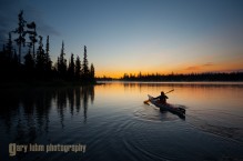 Sea kayaker on Big Lake at dawn, Oregon Cascades.
