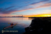 Male sea kayaker in Elliott Bay, Seattle, Washington, at sunrise.