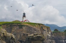 Sea Kayakers paddle beneath the lighthouse on Tatoosh Island near Cape Flattery, the Northwestern-most point in the contiguous US.