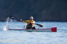 Woman kayaker races her high-performance surf ski kayak at Deception Pass, Washington State.