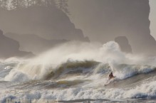 Kayak surfer at First Beach, La Push, surfing winter wave with sea stacks behind. Olympic Coast, Washington State.