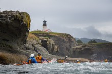 Sea Kayakers paddle beneath the lighthouse on Tatoosh Island near Cape Flattery, the Northwestern-most point in the contiguous US.