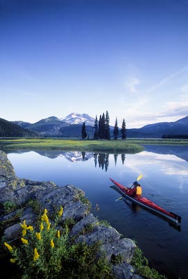 A kayaker paddling into the scene adds the human element at scenic Sparks Lake, OR.